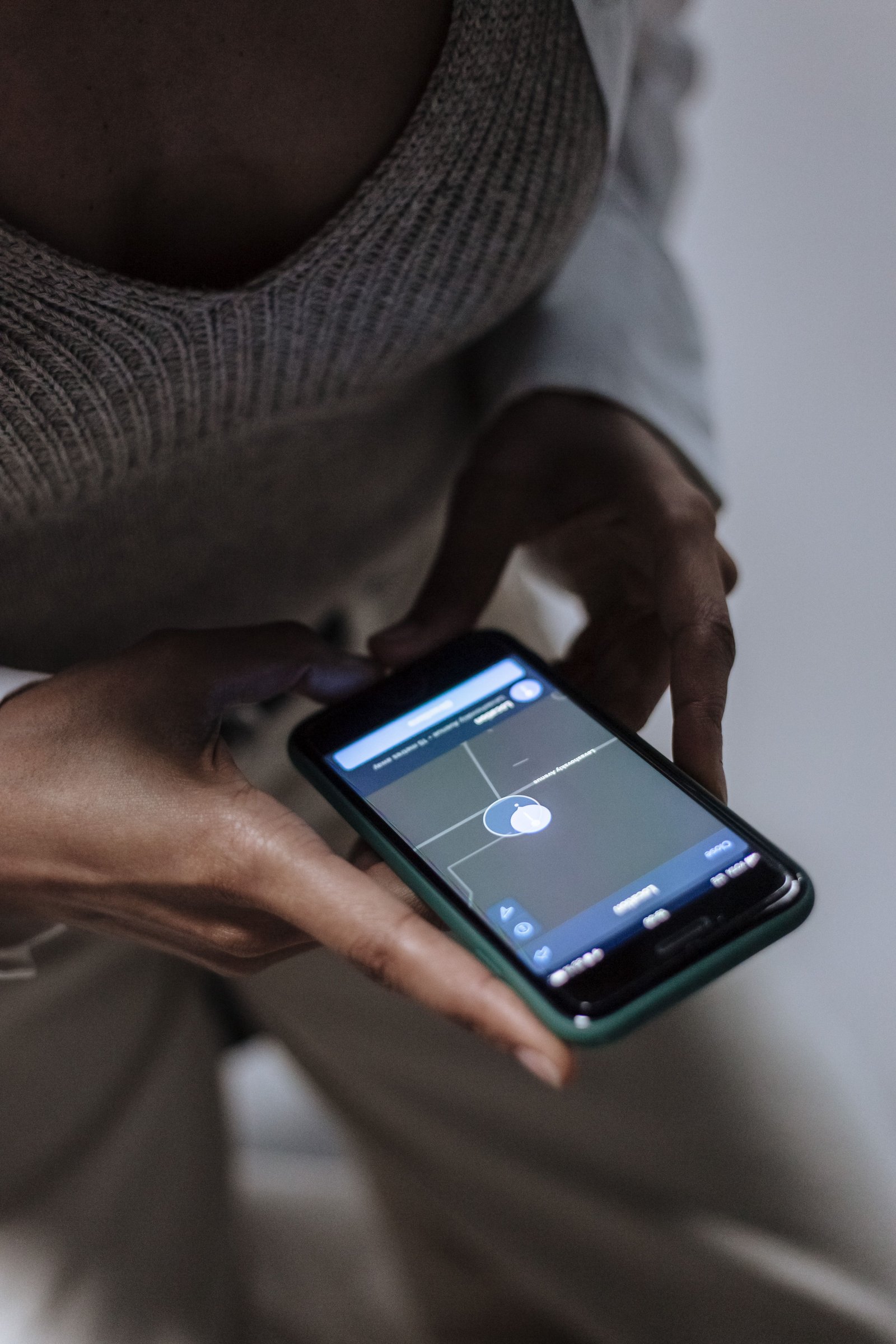 Pessoa monitorando área de exclusão de medida protetiva de urgência em um aplicativo de mapa no smartphone.